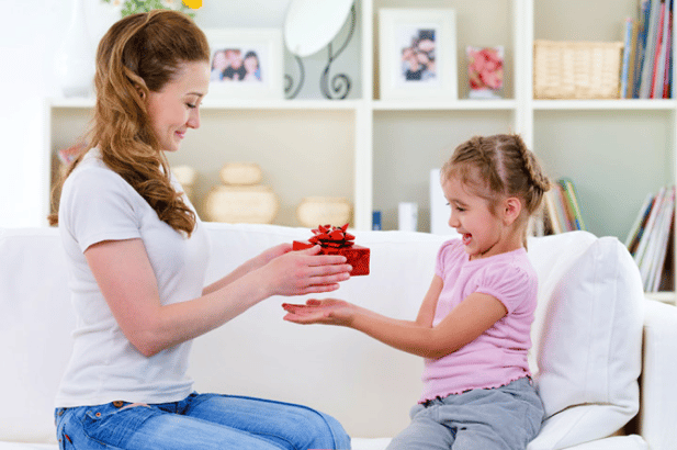 woman gifting a little girl with a gift box